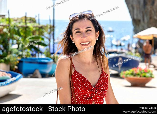 Smiling woman in red summer dress at beach