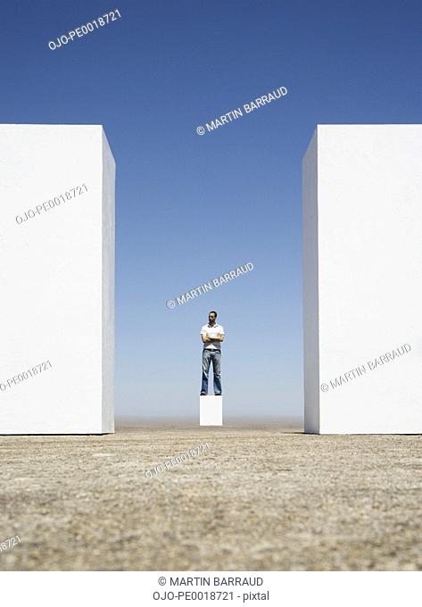 Man standing on box between two walls outdoors