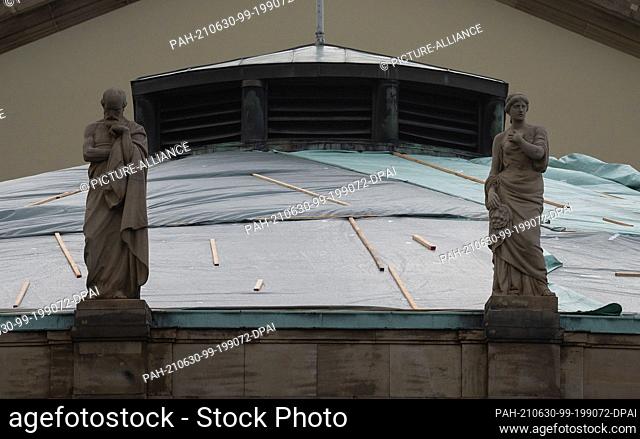 30 June 2021, Baden-Wuerttemberg, Stuttgart: Foil and roof battens are seen on the damaged roof of the State Opera House