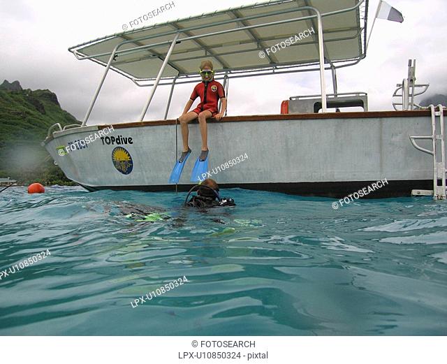 People scuba diving from a boat, Moorea, Tahiti, French Polynesia, South Pacific