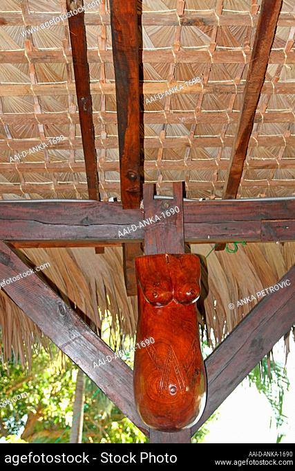 Traditional palm-leaved thatch roof ceiling and wooden torso body sculpure, Ampangorinana Village Nosy Komba Island, Madagascar
