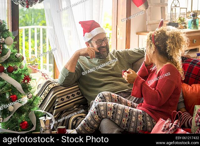 Man having fun with his wife drinking coffee during Christmas celebration at home. Caucasian couple having breakfast on the eve of Christmas