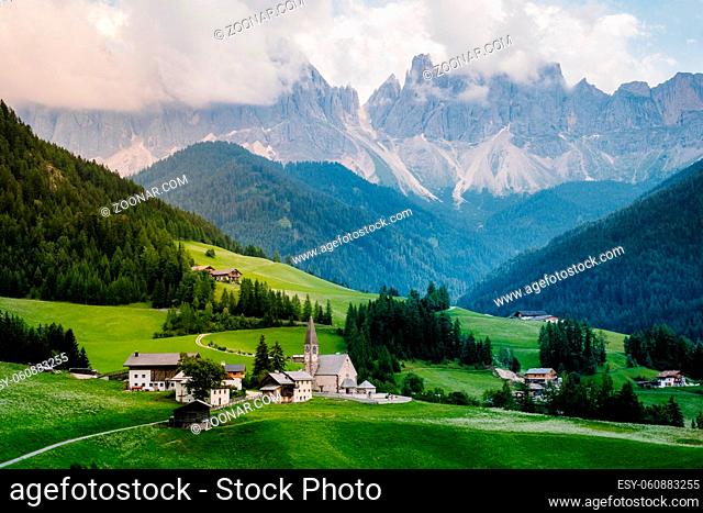 Santa Magdalena village in Val di Funes on the italian Dolomites. Autumnal view of the valley with colorful trees and Odle mountain group on the background