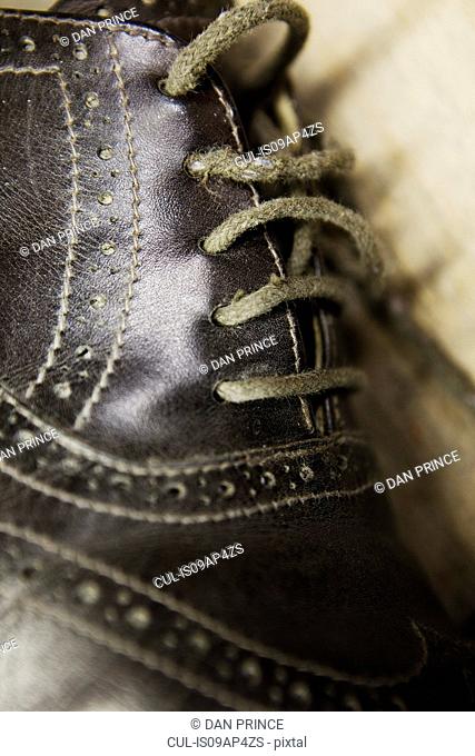 Close up of leather brogue and shoelaces in shoe makers workshop
