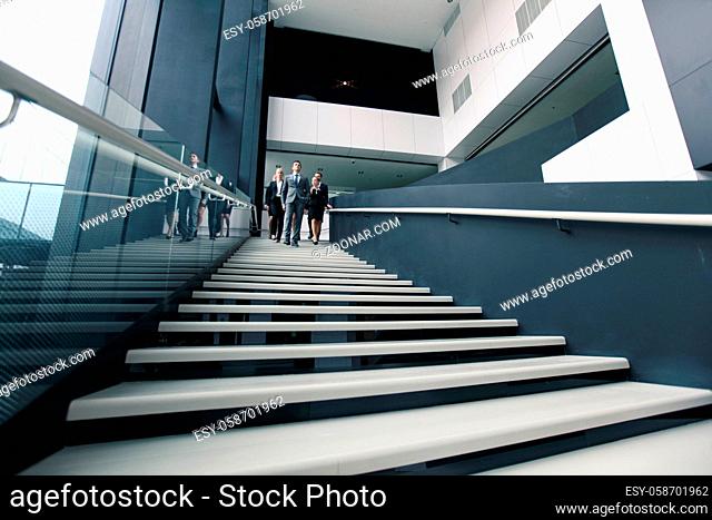 Group of Business people walking down stairs in office building