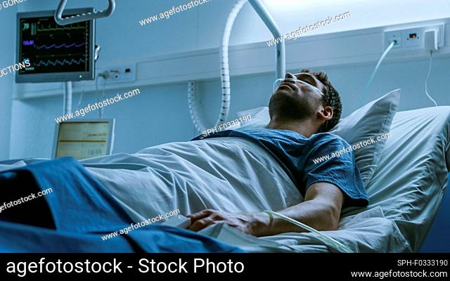 Ill man suffering while lying in a hospital bed