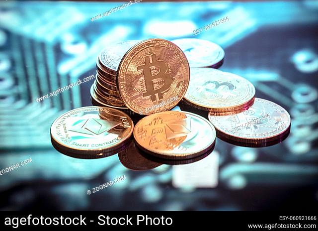 Bitcoin gold, silver and copper coins and defocused printed circuit background. Virtual cryptocurrency concept