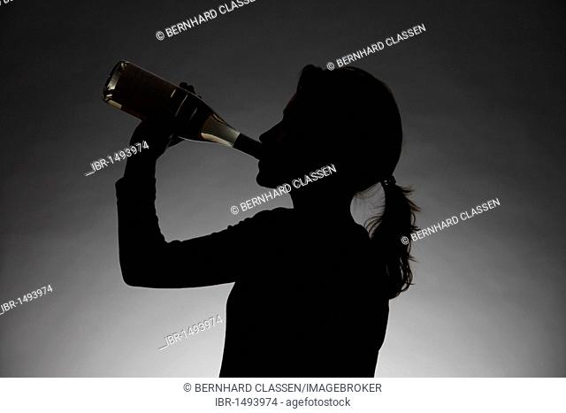 Silhouette of a woman drinking alcohol, symbolic image for alcohol abuse or addiction
