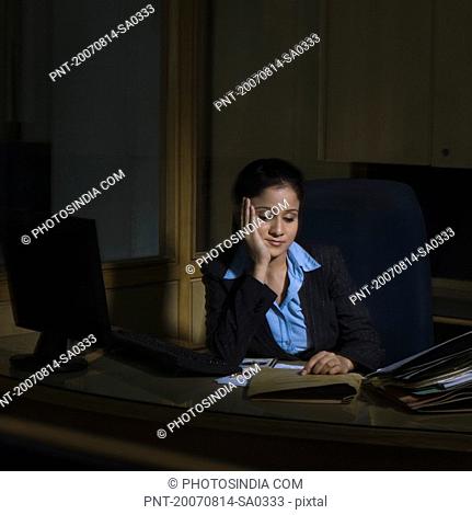 Businesswoman thinking with her hand on her chin in an office