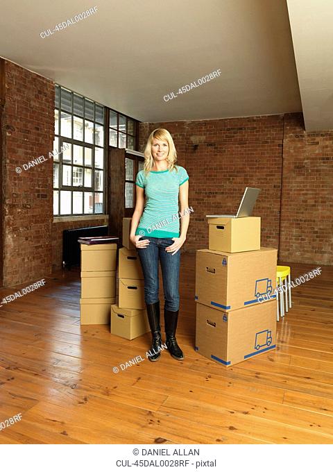 Woman with cardboard boxes in new home