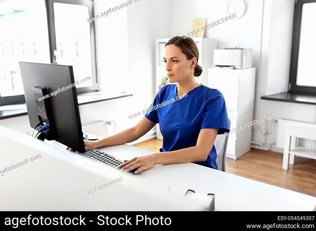 doctor or nurse with computer working at hospital