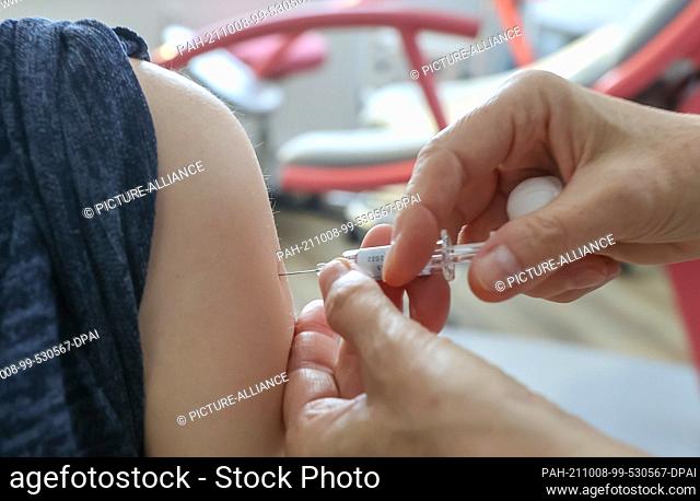 PRODUCTION - 07 October 2021, Saxony, Großpösna: A gynaecologist vaccinates a pregnant woman against influenza with the vaccine ""Vaxigrip Tetra 2021/2022""...