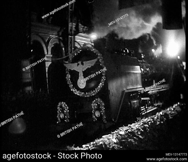 A Steam Train Decorated With Nazi Insignia on the Front Pulls Into a Station at Night - Berlin, Germany