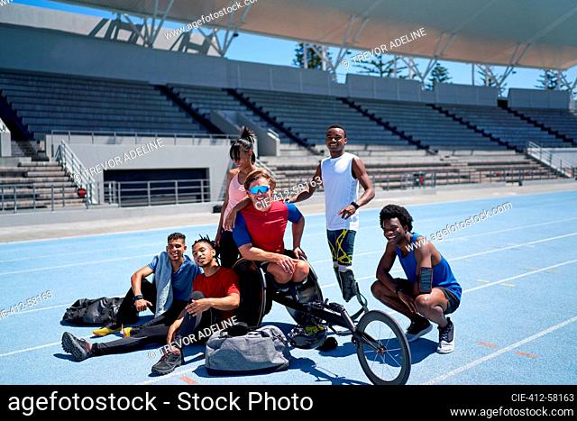 Portrait confident diverse track and field athletes on sunny track