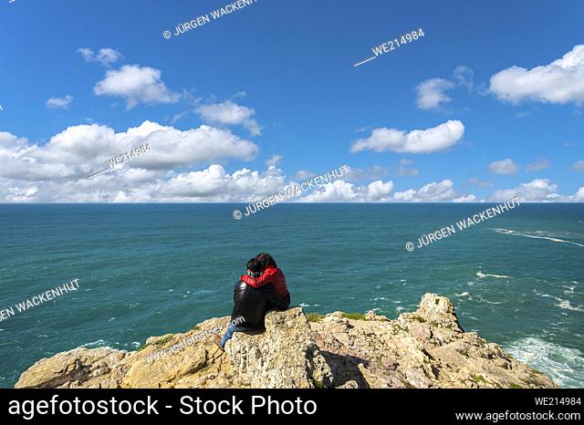 Steep coast at Cabo de Sao Vicente with a young couple, Sagres, Algarve, Portugal, Europe