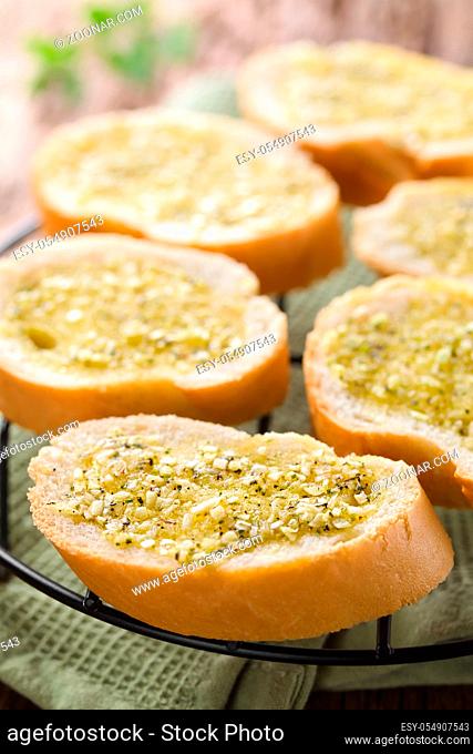 Fresh homemade garlic bread, slices of baguette seasoned with garlic, oregano, salt, pepper and olive oil (Selective Focus