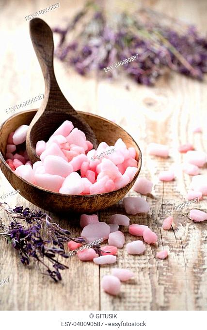 Homeopathic sea salt, lavender dry flowers and wooden surface