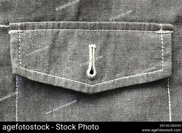 fragment of unbuttoned pocket of the gray textile jacket with white stitches