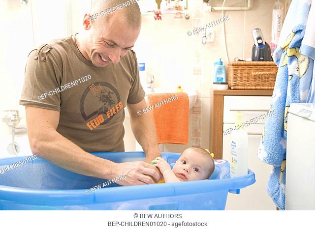 Father bathing a baby
