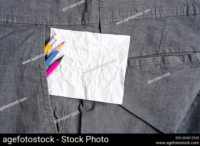 Writing equipment and white note paper inside pocket of man work trousers