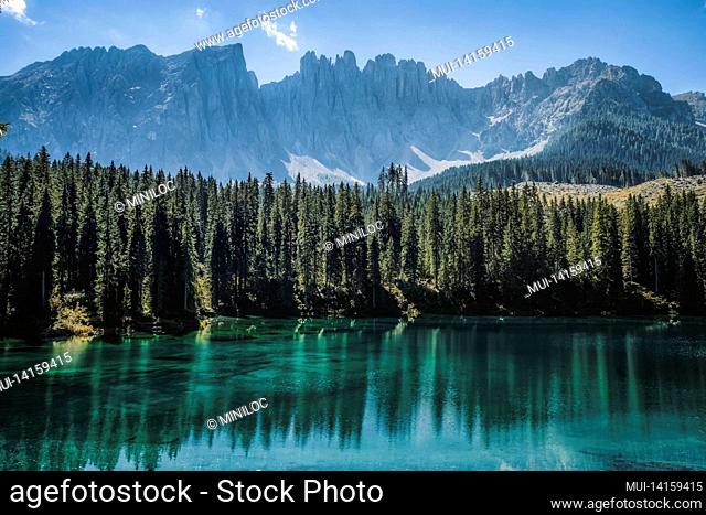wonderful mountain scenery of the turquoise water of the moraine carezza lake lake and silhouette of latemar mountain group peaks in the background