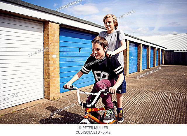 Boys giving friend a ride on bike