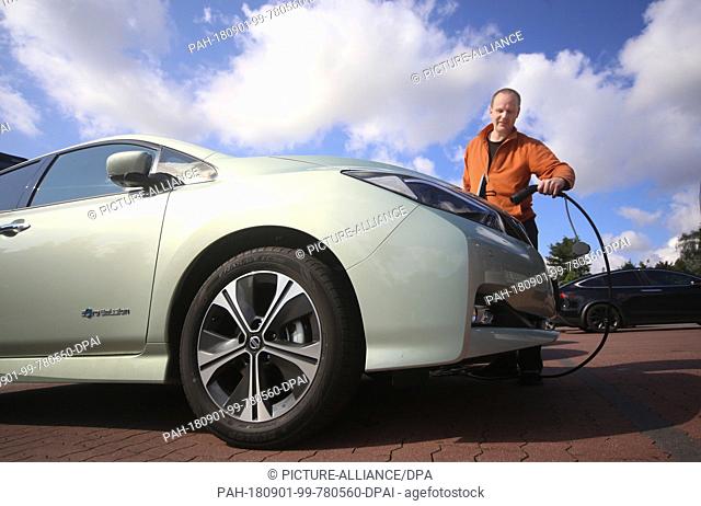 01.09.2018, Mecklenburg-Western Pomerania, Rostock: Benedikt Klees shows how he charges his electric car Nissan Leaf. He participates with his vehicle in the...