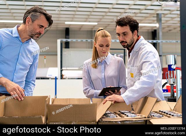 Businesswoman with colleagues taking inventory at warehouse