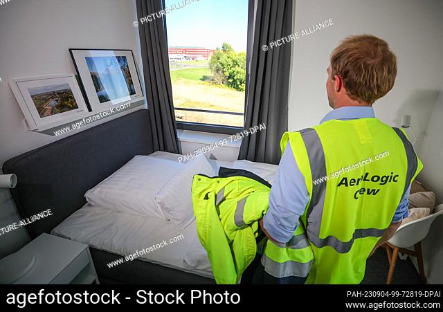 04 September 2023, Saxony, Schkeuditz: An employee wearing a high-visibility vest from AeroLogic stands in a lounge for pilots at the new LEJ Campus