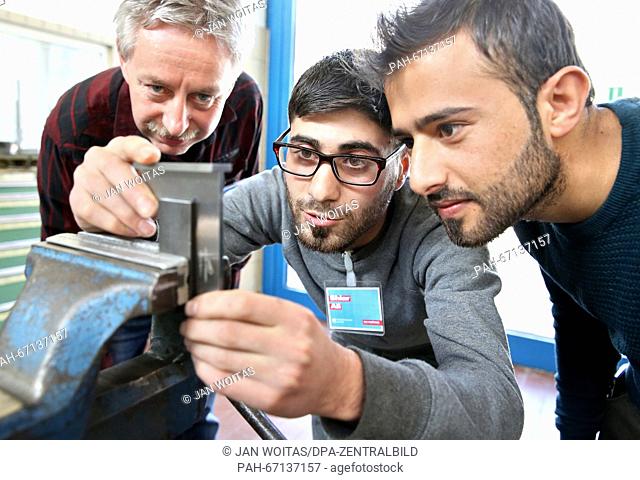 Instructor Frank Blobel (l-r) watching Shiar Ali and Ibrahim Ezzedin from Syria during their internhip at the metal workshop of the Chamber of Crafts in...