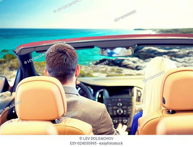 drive, auto trip, travel, tourism and people concept - close up of couple driving in cabriolet car from back over sea shore background