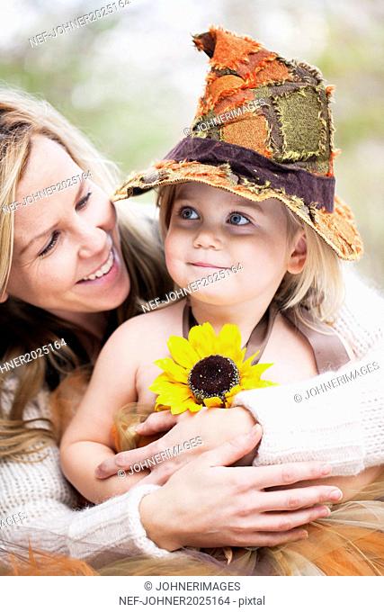 Smiling girl wearing witch hat with mother