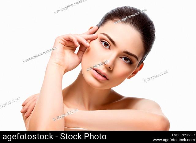 Beautiful young woman looking to camera and touching face. Isolated over white background. Copy space