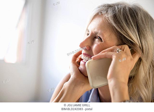 Smiling Caucasian woman talking on cell phone