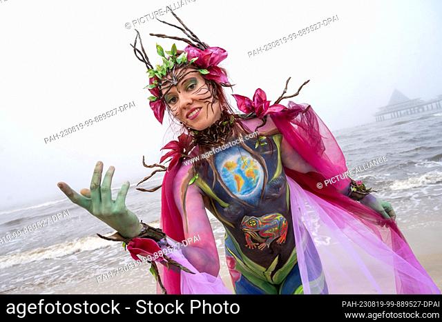 19 August 2023, Mecklenburg-Western Pomerania, Heringsdorf: Model Juliane presents her body painted by body painting artist Andrea Stern at the Bodypainting...