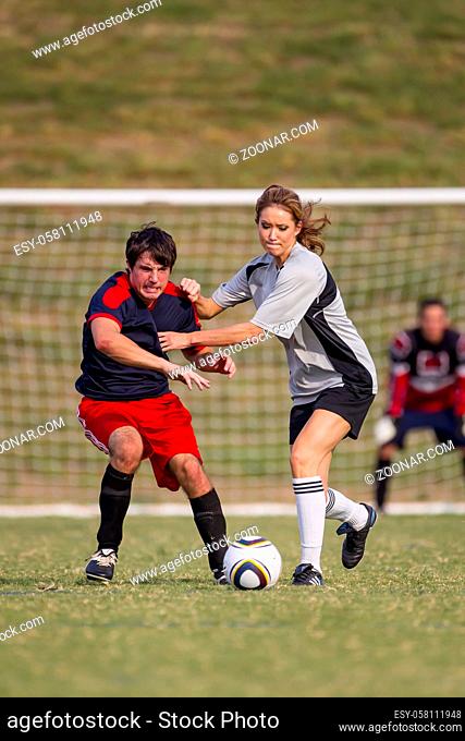 Image of a male and female soccer player in action