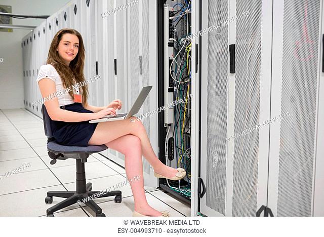 Smiling woman doing data storage in data center