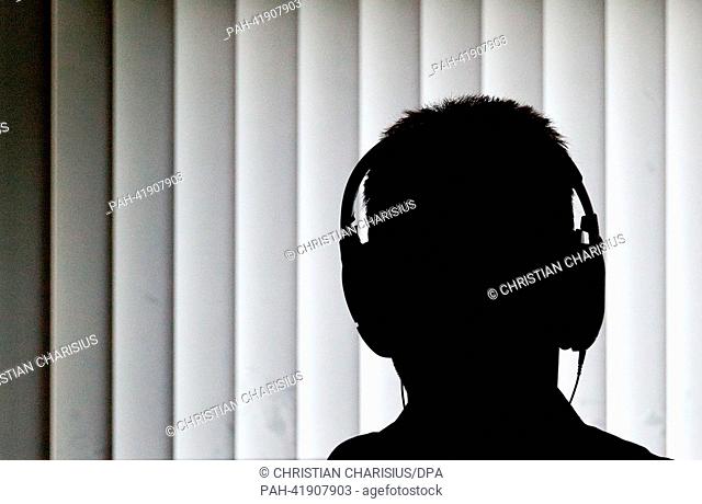 (ILLUSTRATION) An officer sits with headphones for a telephone surveillance in front of a computer in an office of the Federal Police Station crime fighting in...