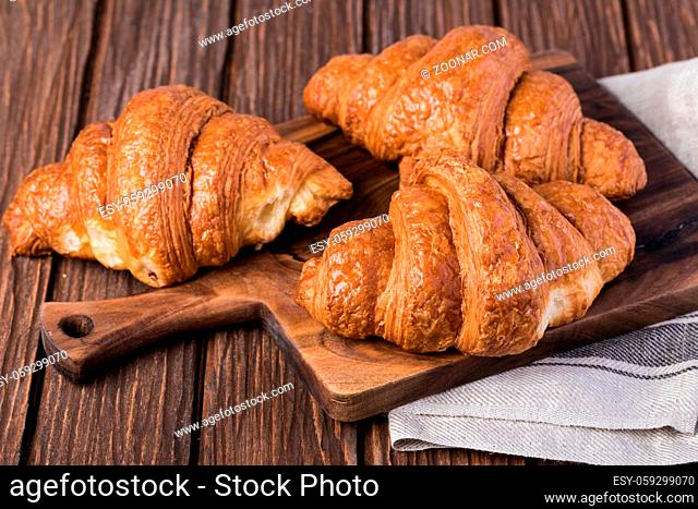 freshly baked croissants on wooden table