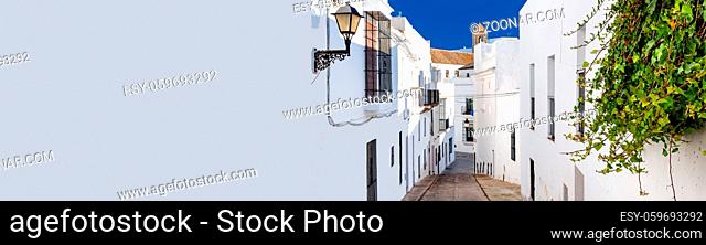 Horizontal cropped image with white copy space wall narrow street of Vejer de la Frontera spanish picturesque village, popular hilltop town municipality in...