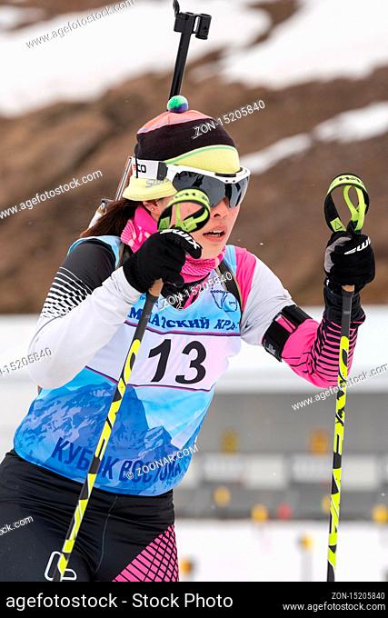 Korean sportswoman biathlete Yu Seolhee skiing on distance biathlon complex after rifle shooting. Open regional youth biathlon competitions East Cup