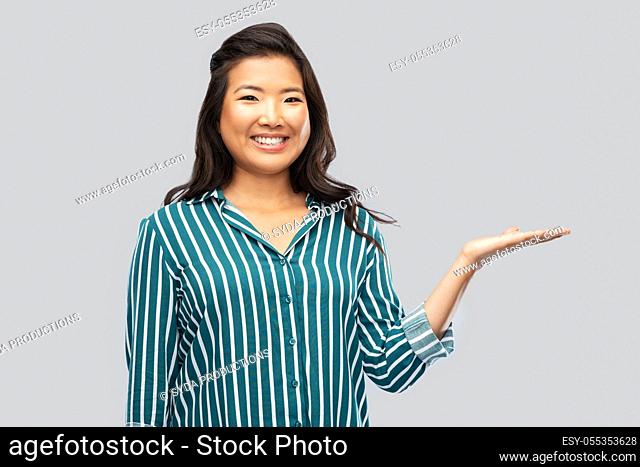 happy asian woman holding something on hand