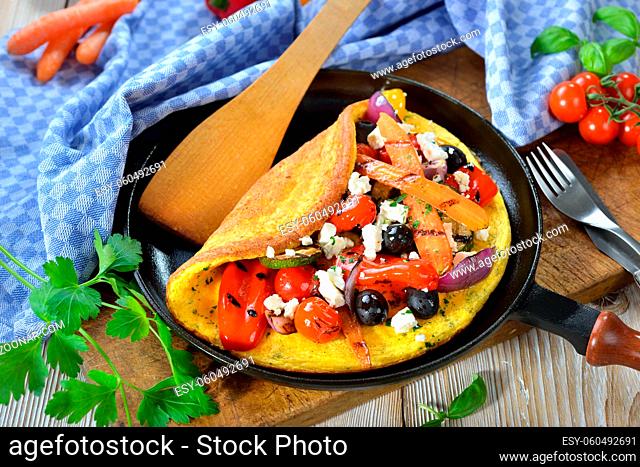 Deftiges vegetarisches Omelett griechische Art mit Gemüse vom Grill und Fetakäse ? Omelette Greek style with grilled vegetables and feta cheese served in a...