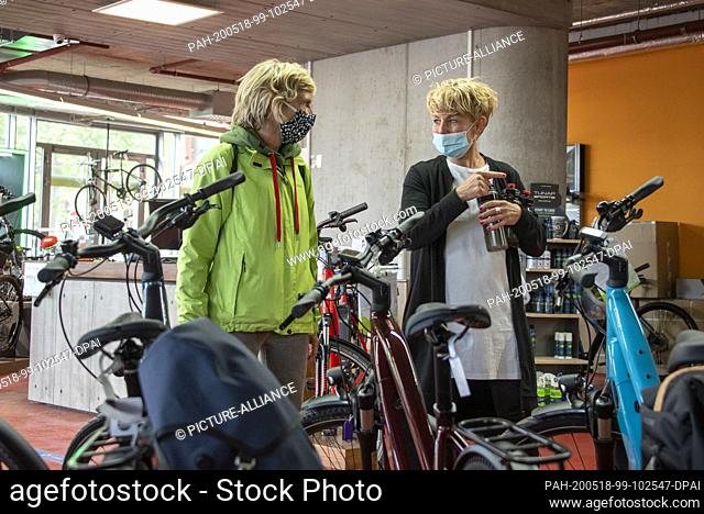 14 May 2020, Saxony-Anhalt, Magdeburg: Daniela Held (r), bicycle saleswoman, advises a customer who is interested in a new bicycle