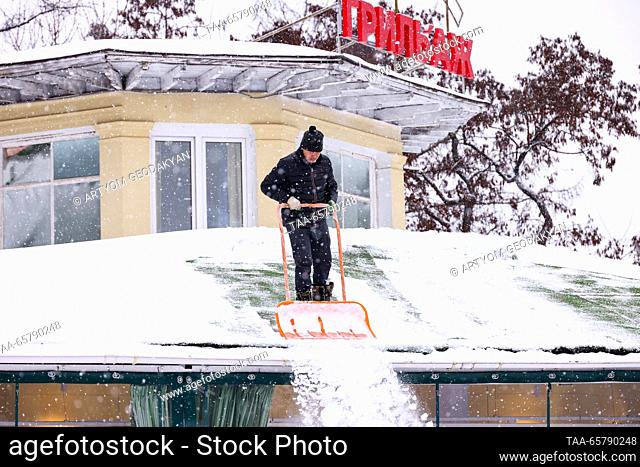 RUSSIA, MOSCOW - DECEMBER 15, 2023: Clearing snow off a roof at the VDNKh exhibition centre and park. Artyom Geodakyan/TASS