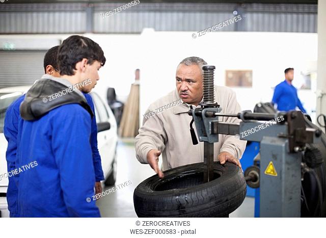 Instructor and trainees in repair garage