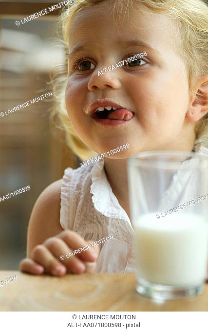 Little girl enjoying glass of milk