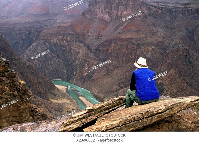 Grand Canyon National Park - A backpacker on the South Kaibab Trail in the Grand Canyon takes a break to contemplate the inner canyon and the Colorado River