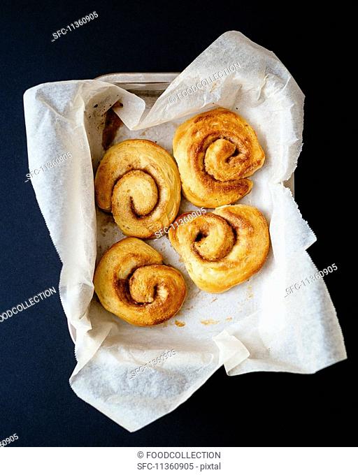 Four cinnamon buns on piece of paper