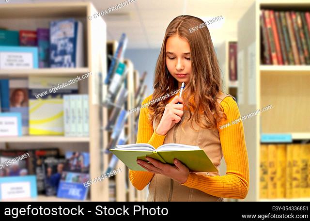 student girl with book and pen at library
